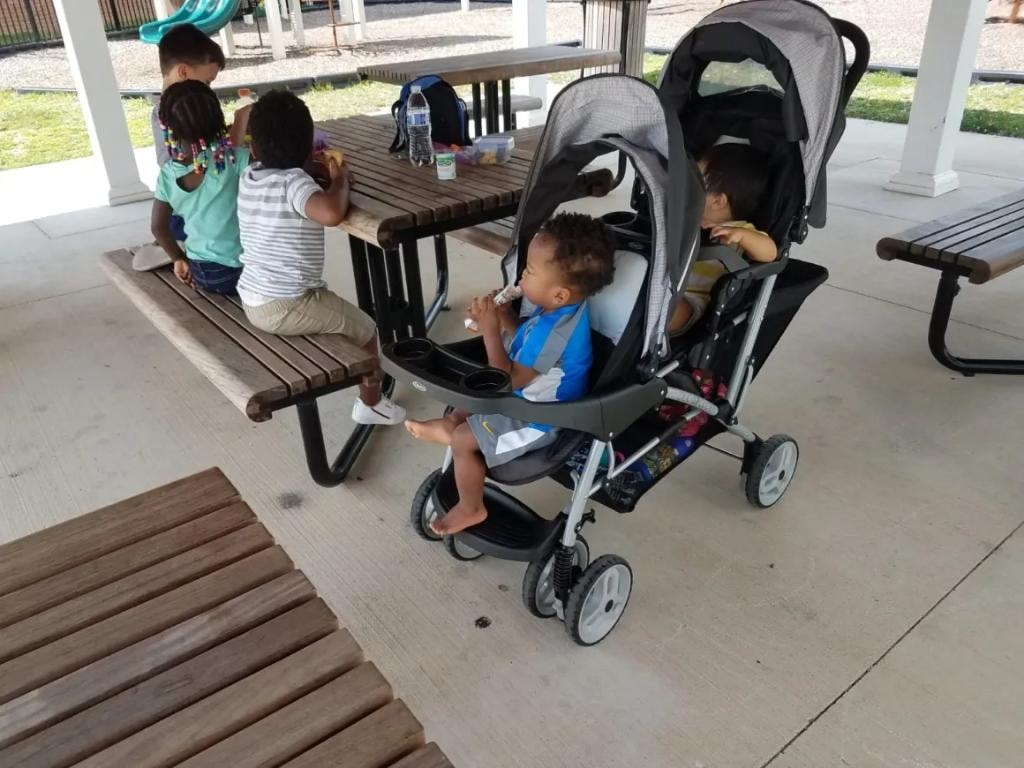 Children enjoying a snack together at a park picnic table